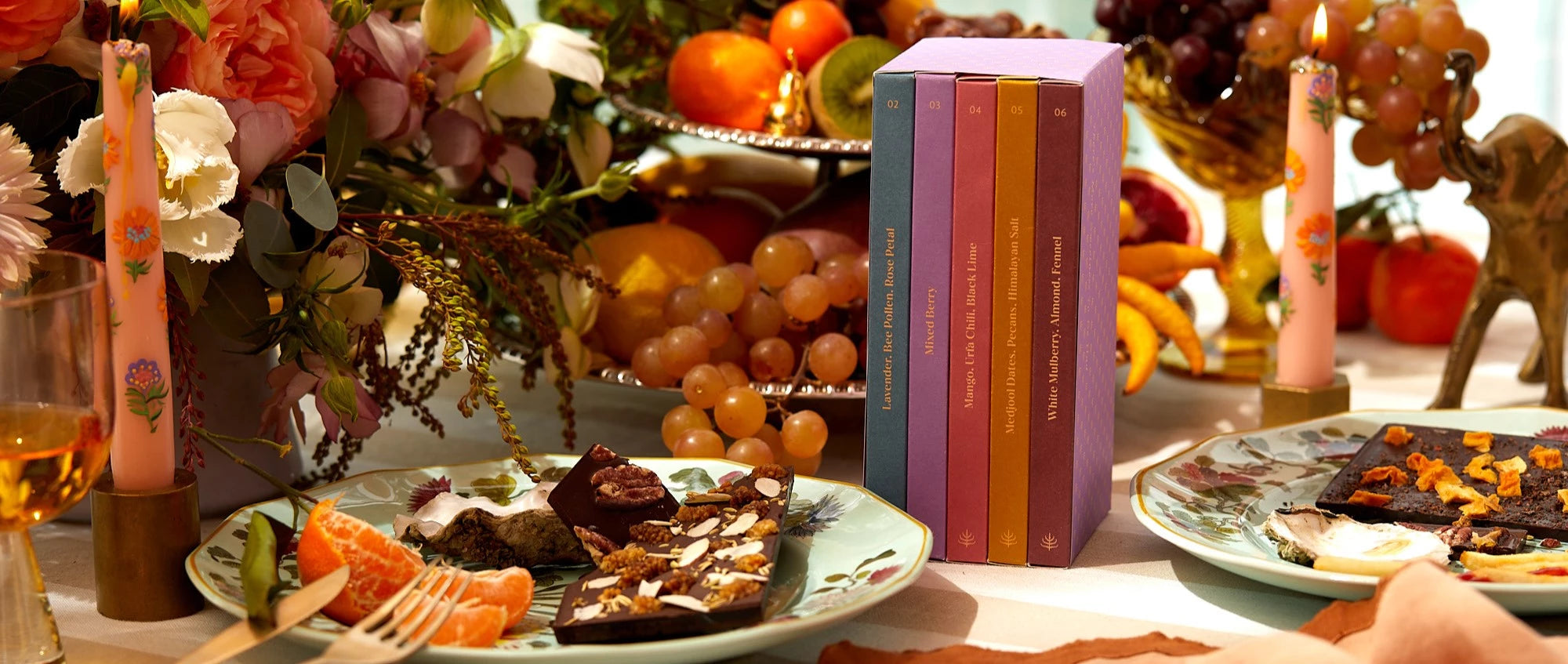 A gift set of chocolate bars sits on the table of a dinner party.