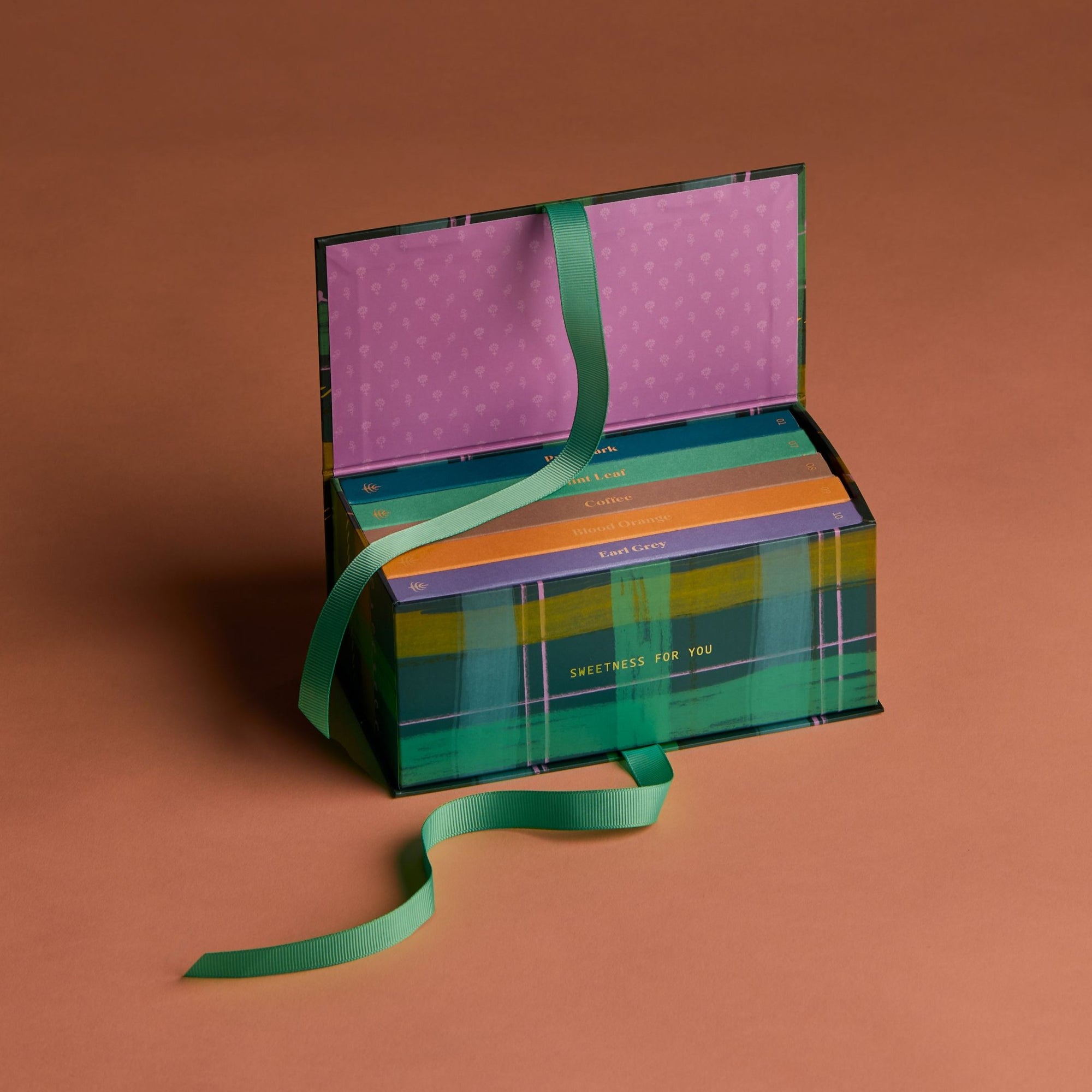 Colorful gift box with a green ribbon on a brown background