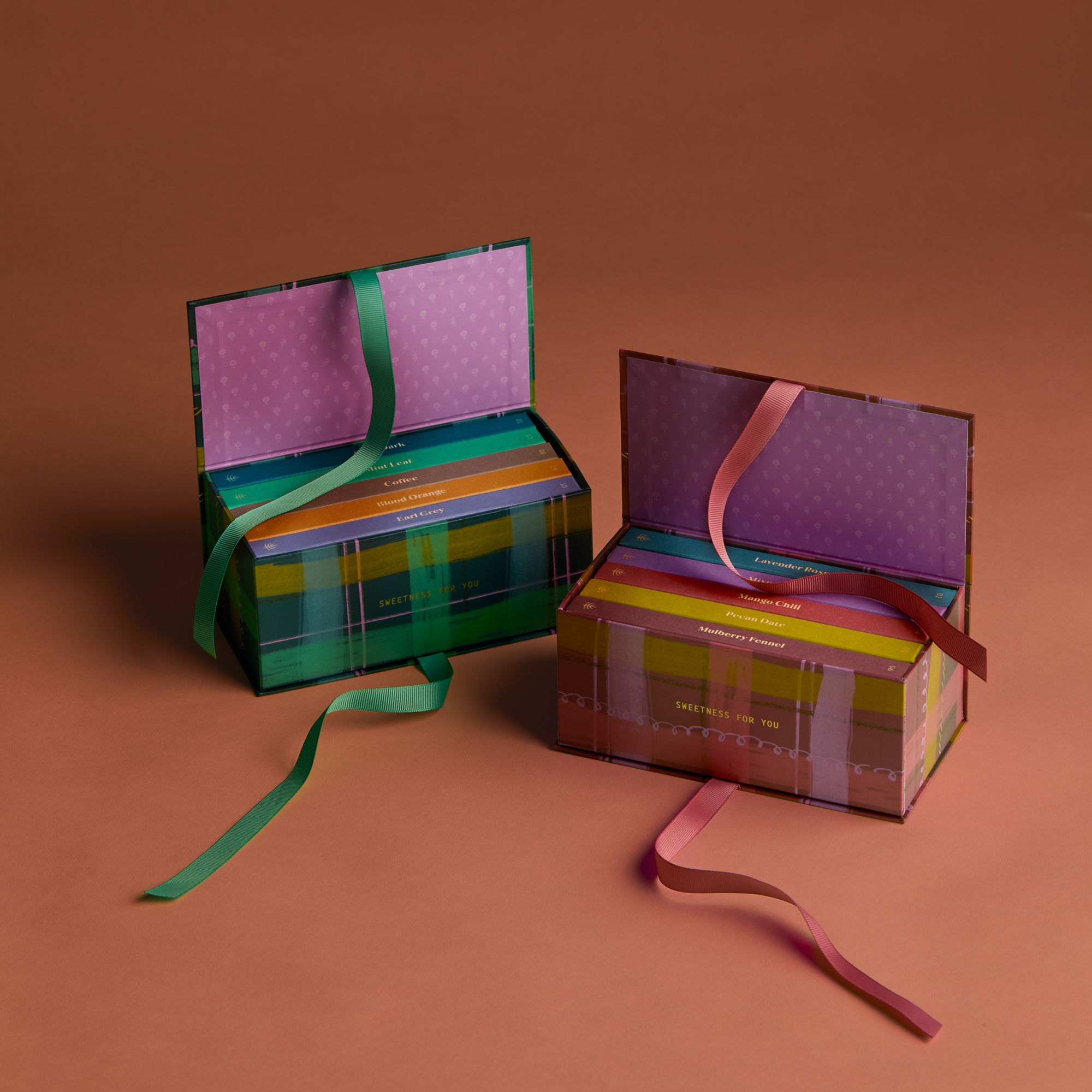 Two colorful gift boxes with ribbons on a brown background