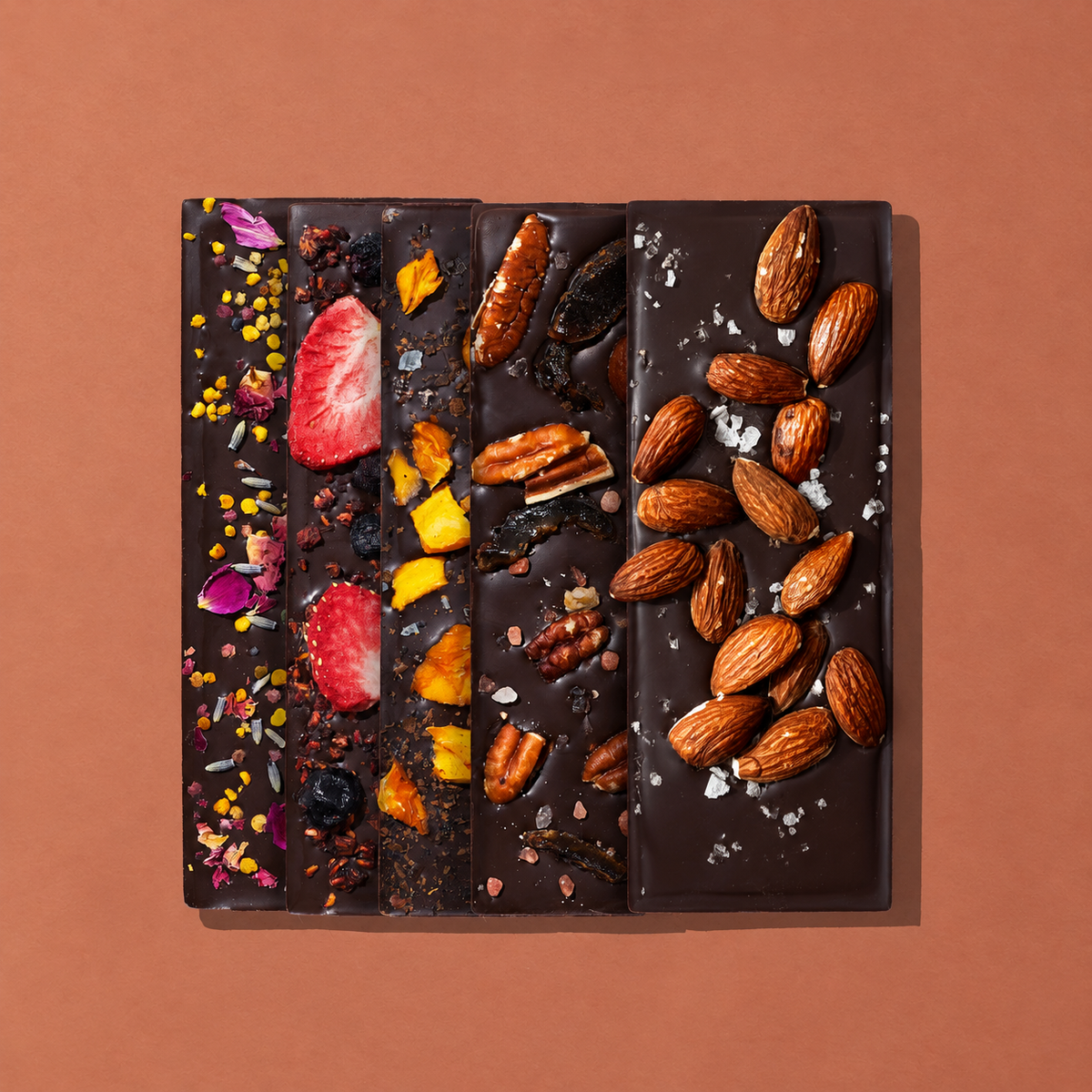 5 Spring and Mulberry bars topped with fruits, nuts, florals and spices on a warm beach background. 