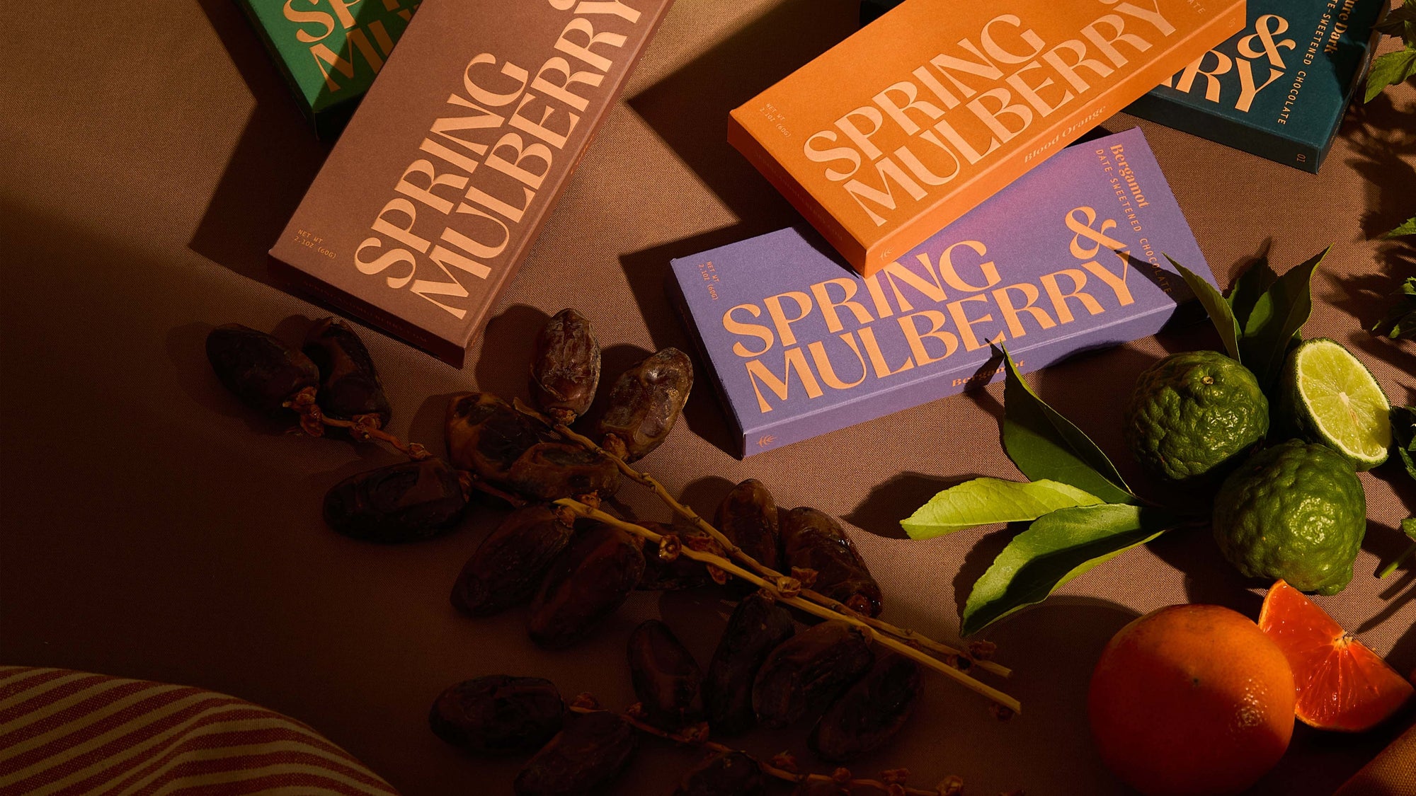 A tablescape filled with fruits and Spring & Mulberry chocolate boxes.