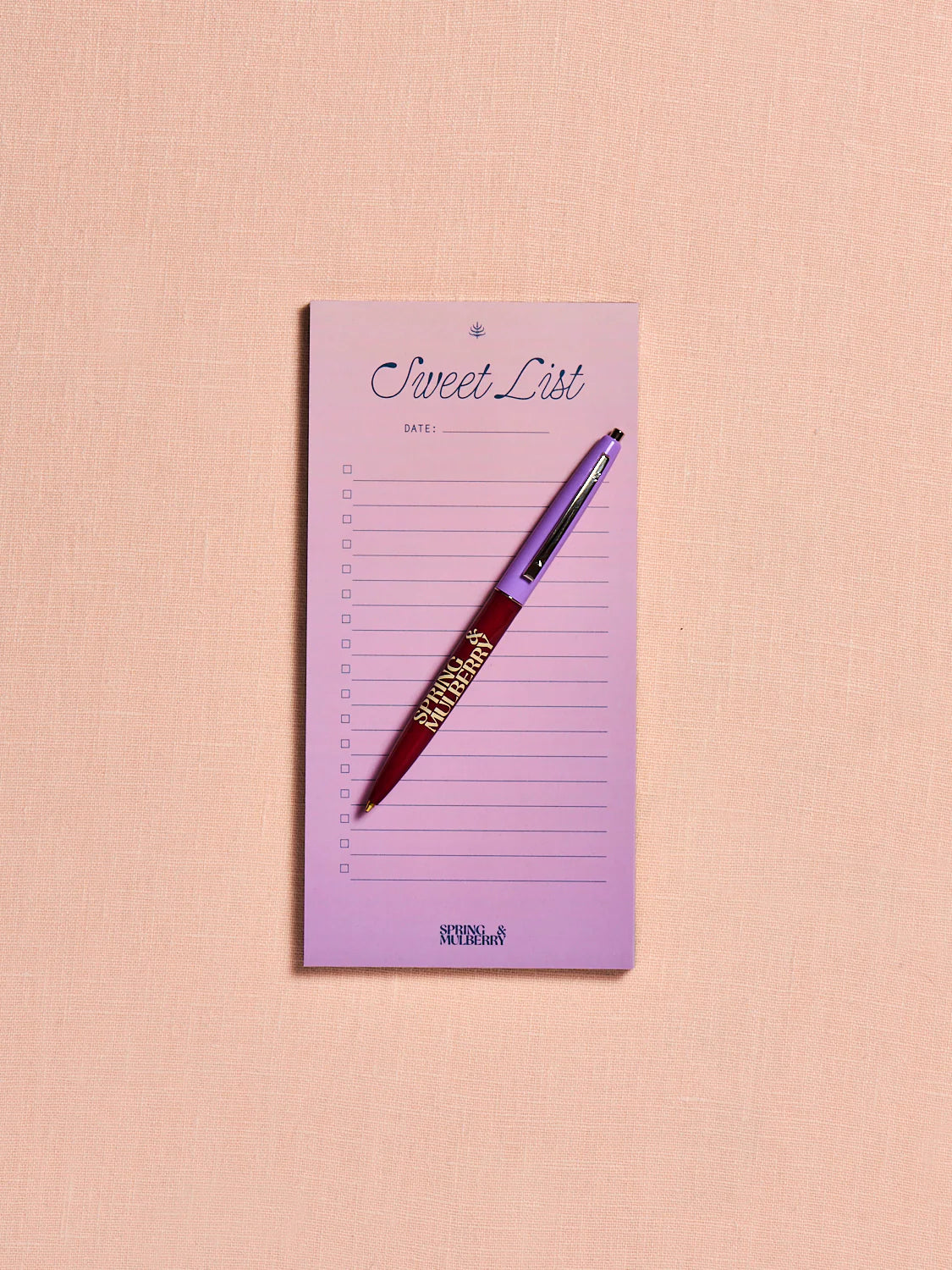 Lavender ombre notepad titled 'Sweet List' with a spring and mulberry pen on a pink background