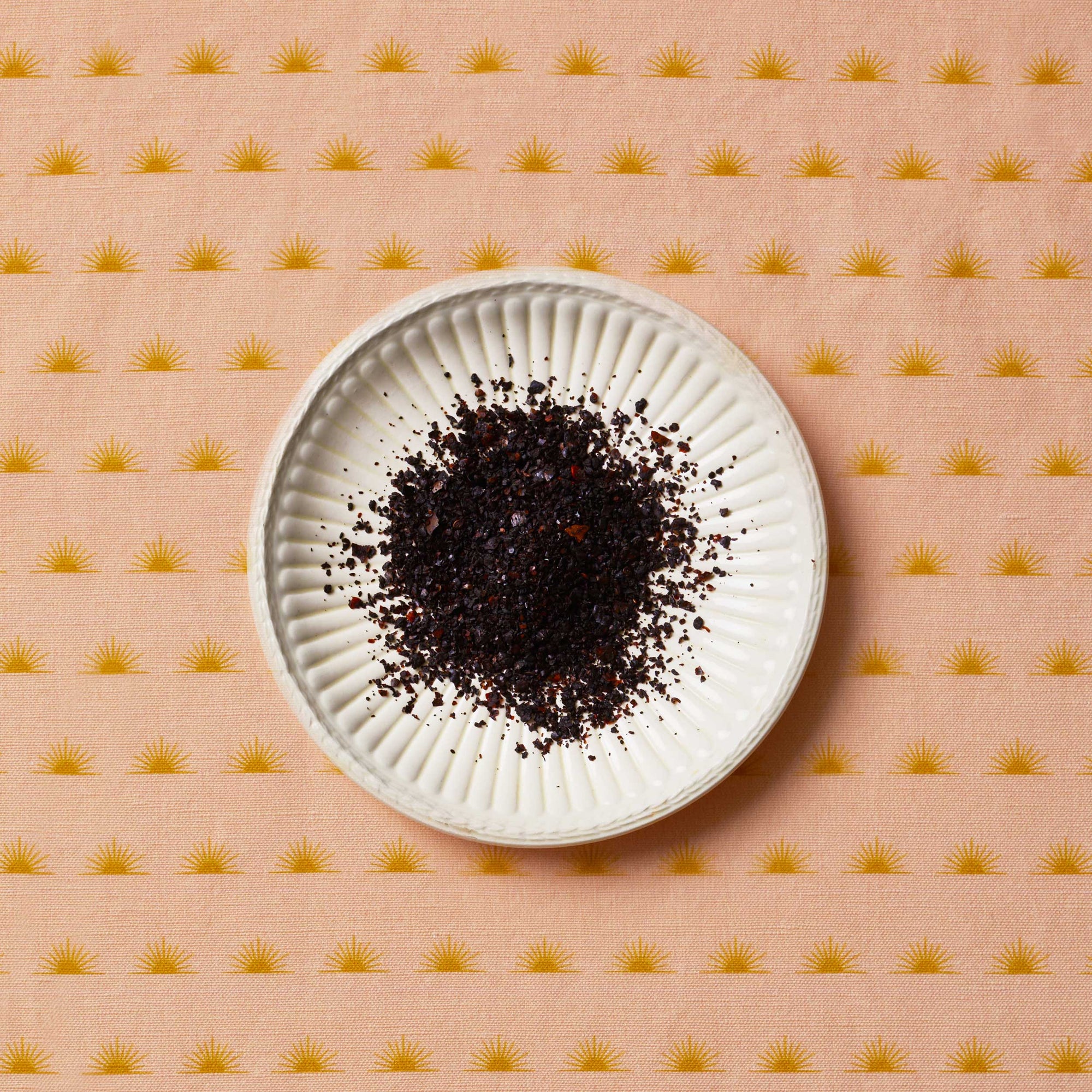 Urfa Chili sitting on a white plate on top of a patterned tablecloth